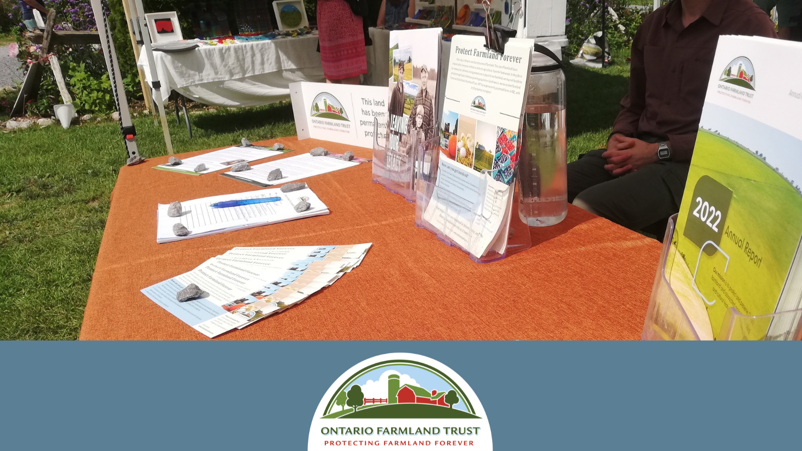 A table is covered with outreach materials and brochures for OFT.